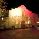 Der Eingang des Fort Alamo Saloon wird hell angestrahlt. Fackeln leuchtet das Gebäude.