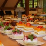 Ein Tisch voller Kuchenstücke auf Tellern.