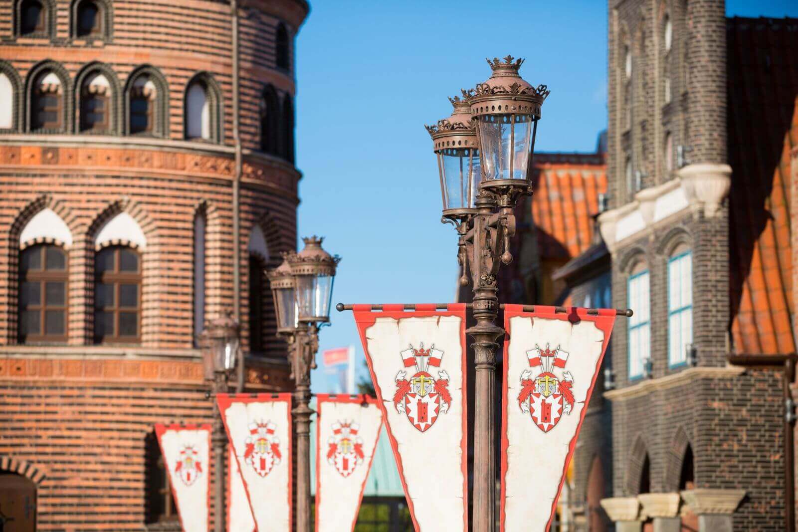 Die Laternen tragen Wimpel mit dem HANSA-PARK-Wappen. Im Hintergrund hanseatische Arkaden.