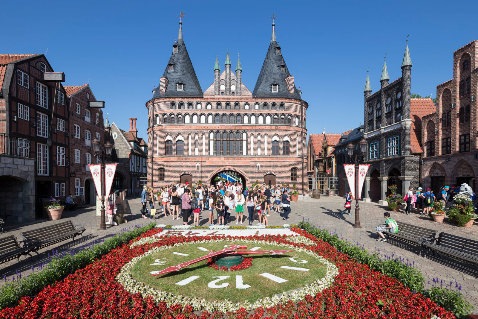 Eine Gruppe von jungen Menschen steht hinter der Blumenuhr, aber vor dem Holstentor.