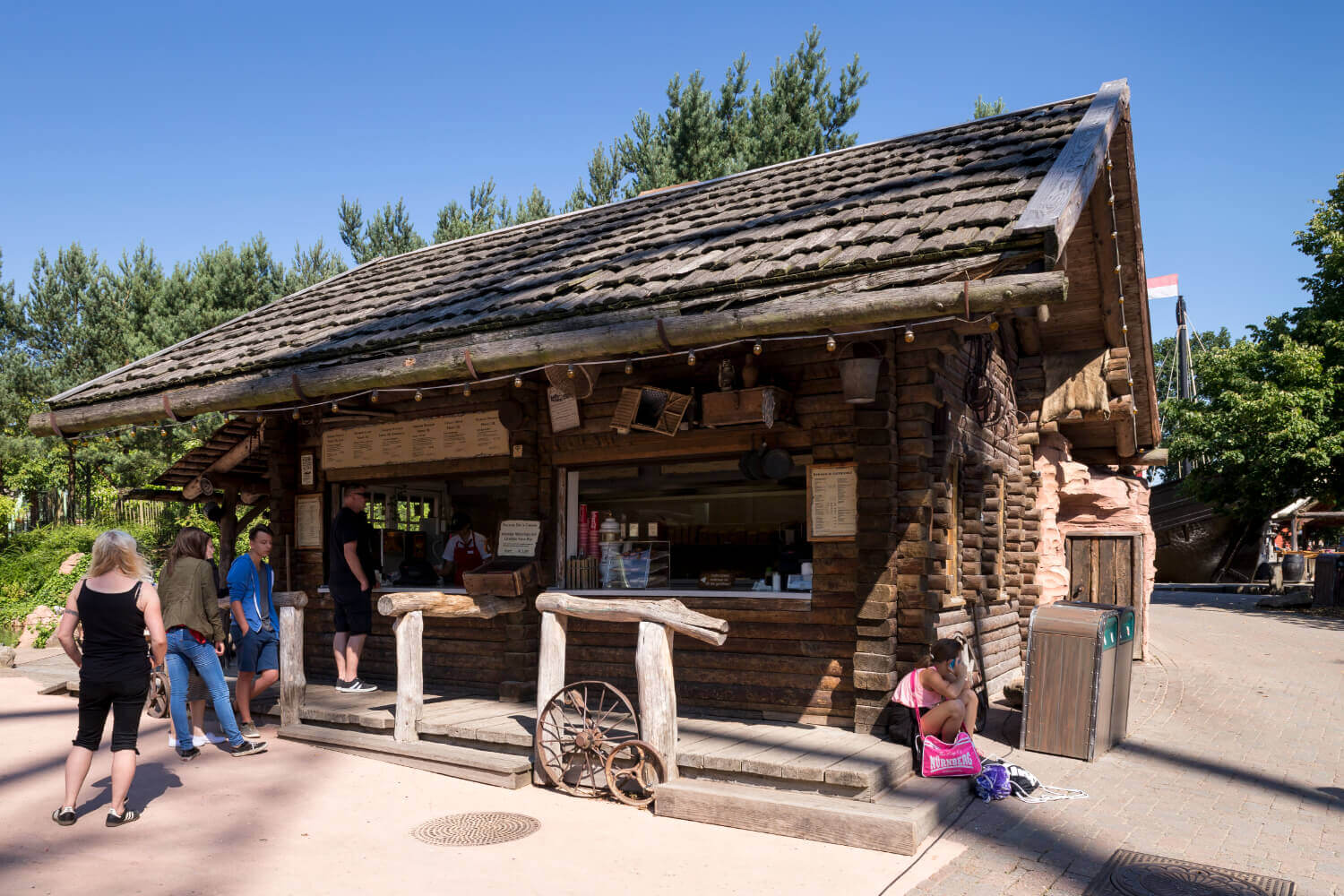 Das Gebäude des Kiosk Miners Camp. Es stehen Gäste für Essen an. Auf der Stufe sitzt ein Mädchen.