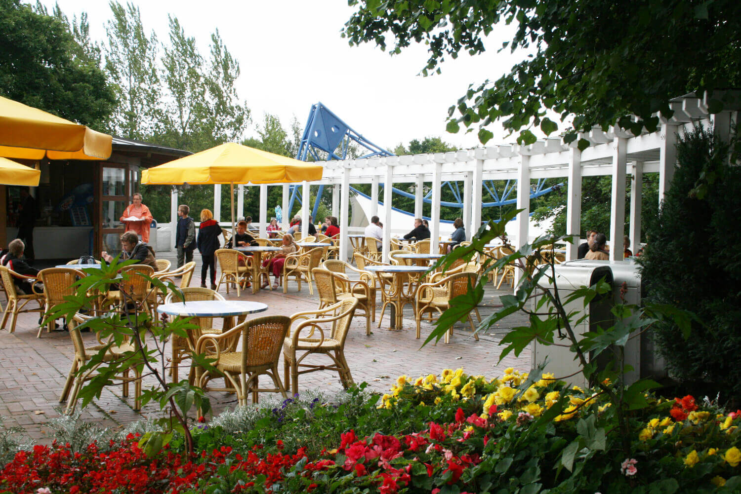 Auf der Terrasse des Kiosk Zeebrugge stehen Stühle. Er ist geöffnet. Ein Schirm spendet Schatten.