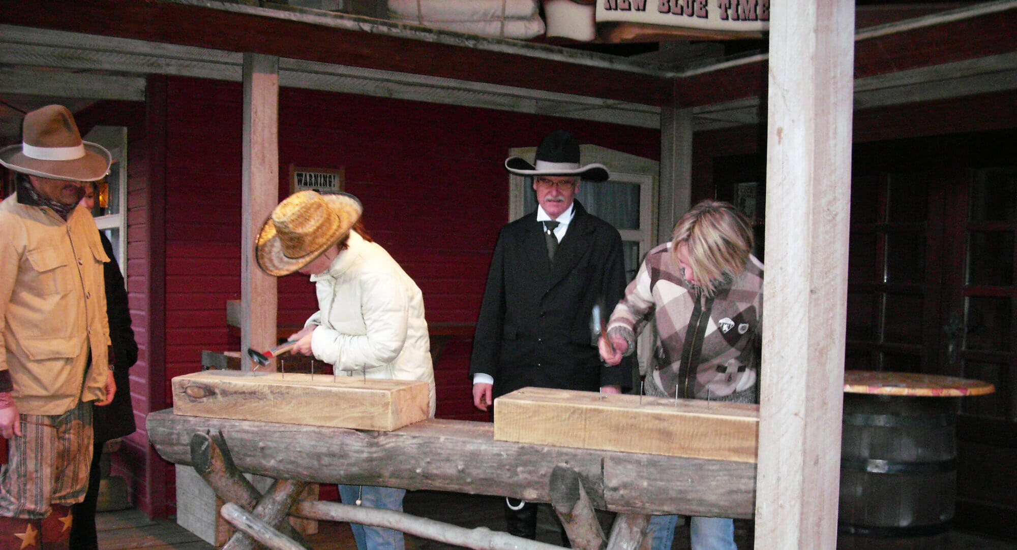 Zwei Cowboys beaufsichtigen den Wettkampf des Wettnagels mit zwei Teilnehmern.