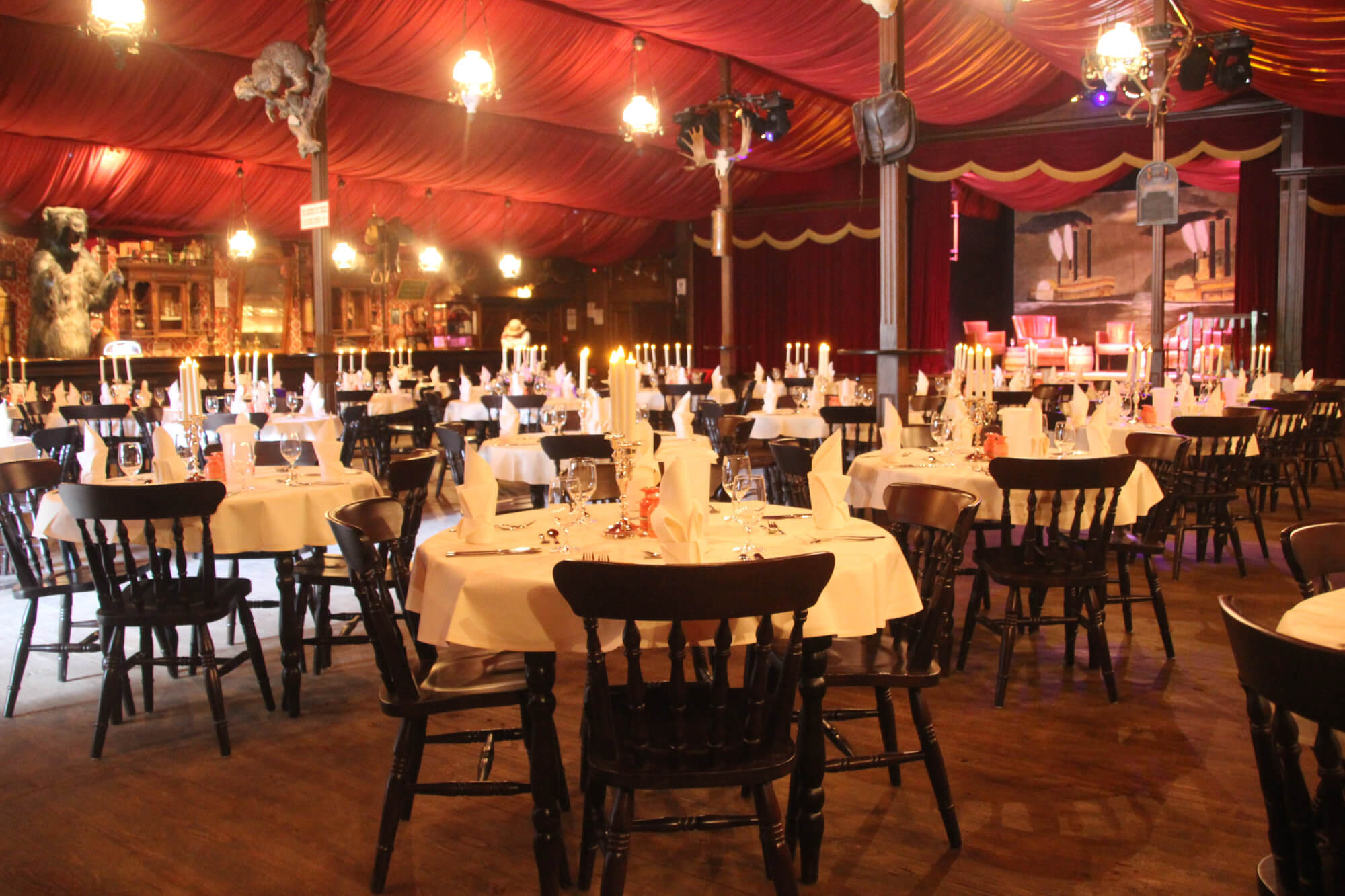 Die Tische des Fort Alamo Saloon sind feierlich eingedeckt. Auf der Bühne sind Sessel.